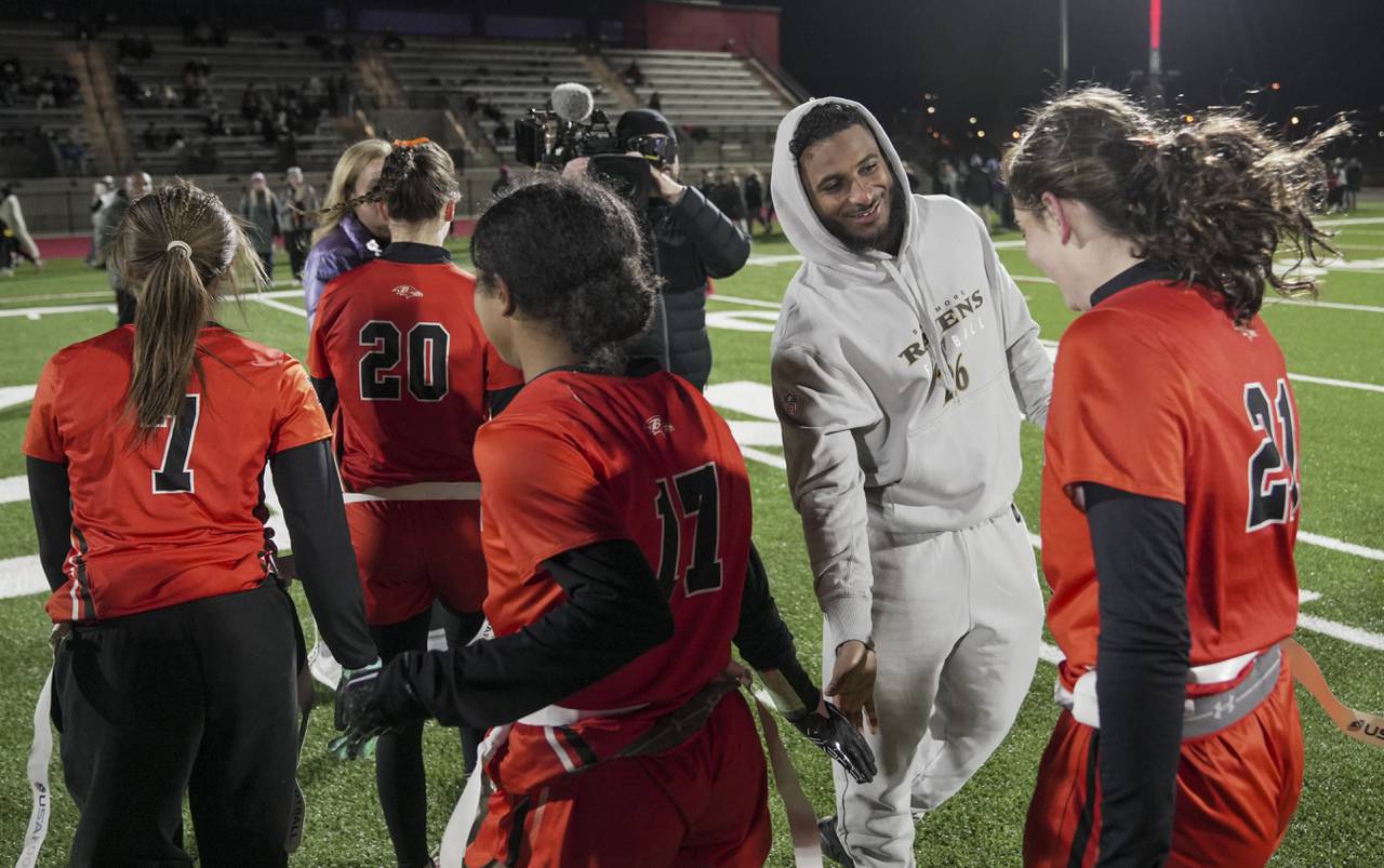 Baltimore Ravens safety Geno Stone (26) high fives Middletown players during the Girls flag semifinals at the Under Armour’s “The Stadium at the House” in Baltimore, Wednesday.