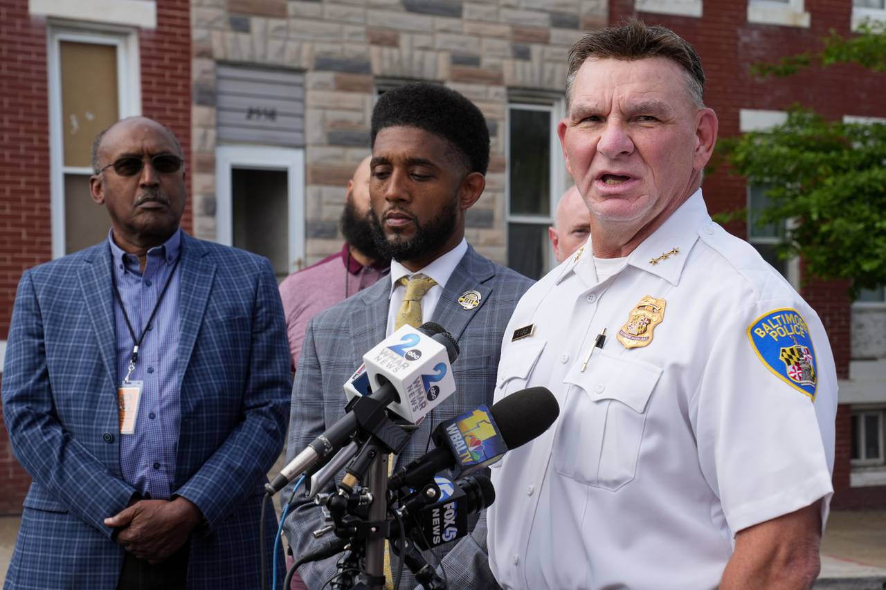 Deputy Commissioner Richard Worley, right, stands next to Baltimore Mayor Brandon Scott while speaking at a press conference on May 11, 2023.