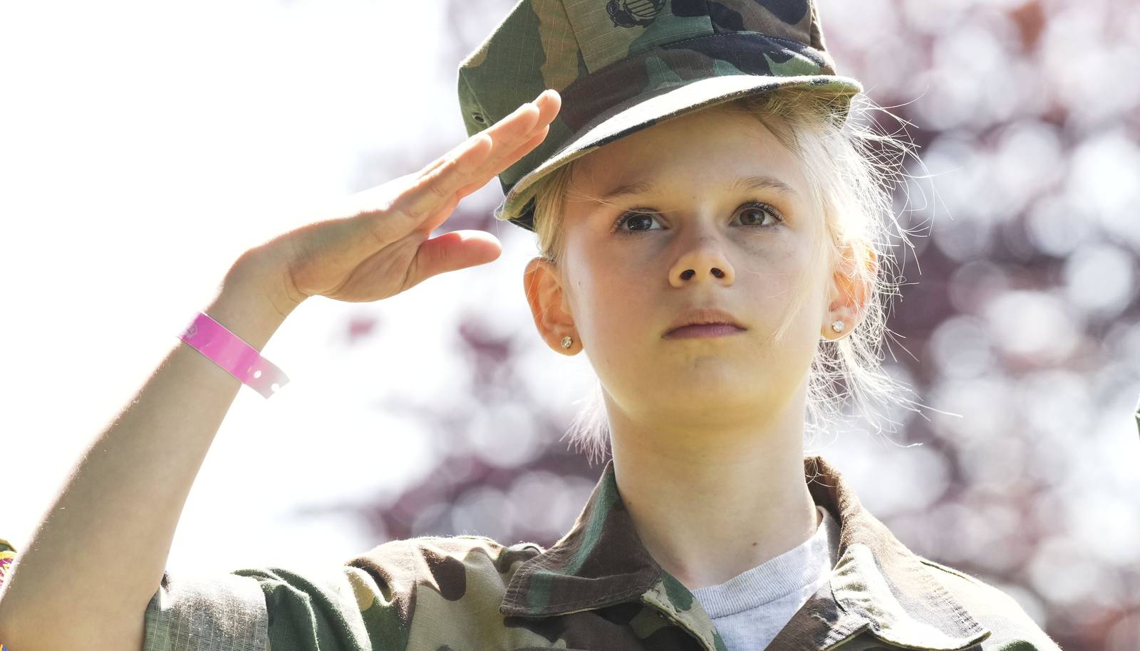 Natalie Latchford, 11, salutes before she plants an American flag on a gravesite at Dulaney Valley Memorial Gardens on May 27, 2023.