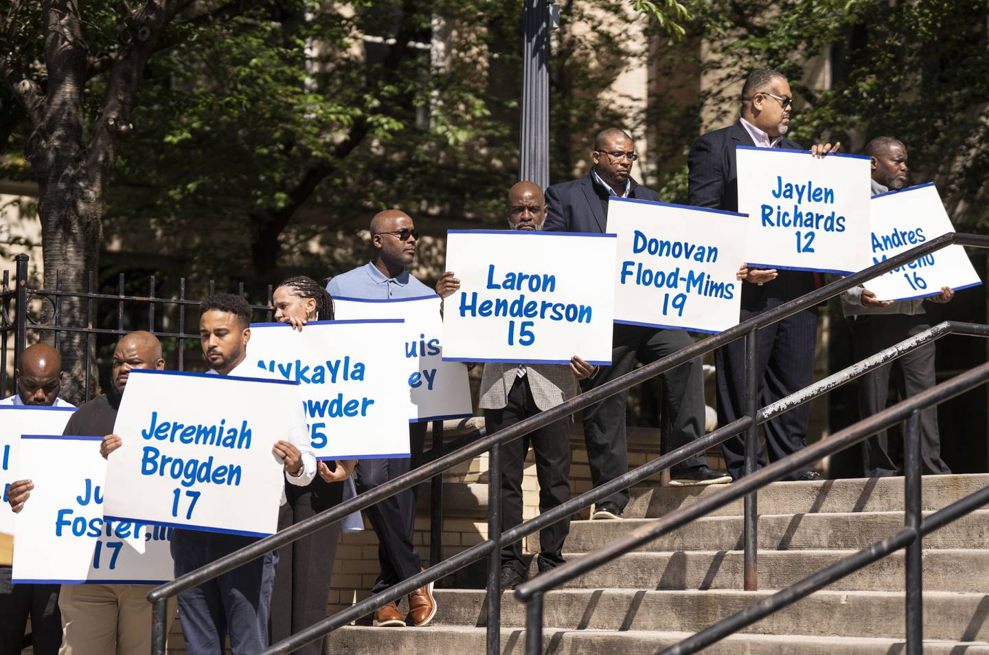 District staff holds up signs with the name of students with the year they would have graduated who have passed from gun violence this year during the Peace and Remembrance Day, at Baltimore City Public Schools District office, in Baltimore, Thursday, May 25, 2023.