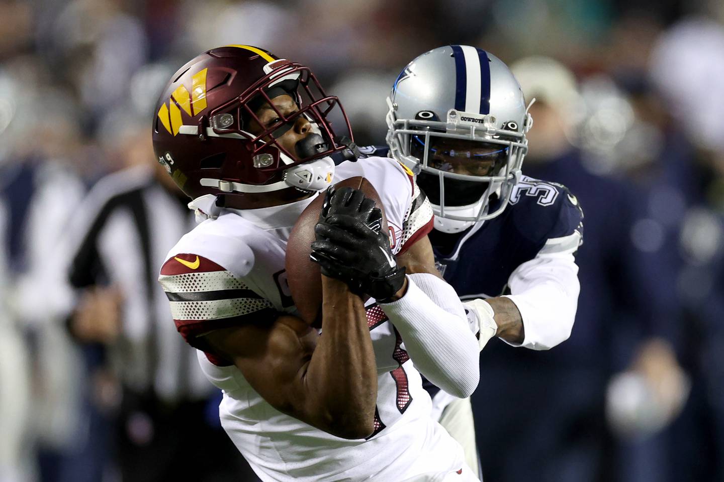 LANDOVER, MARYLAND - JANUARY 08: Wide receiver Terry McLaurin #17 of the Washington Commanders catches a first down pass in front of cornerback Trayvon Mullen #37 of the Dallas Cowboys at FedExField on January 08, 2023 in Landover, Maryland.