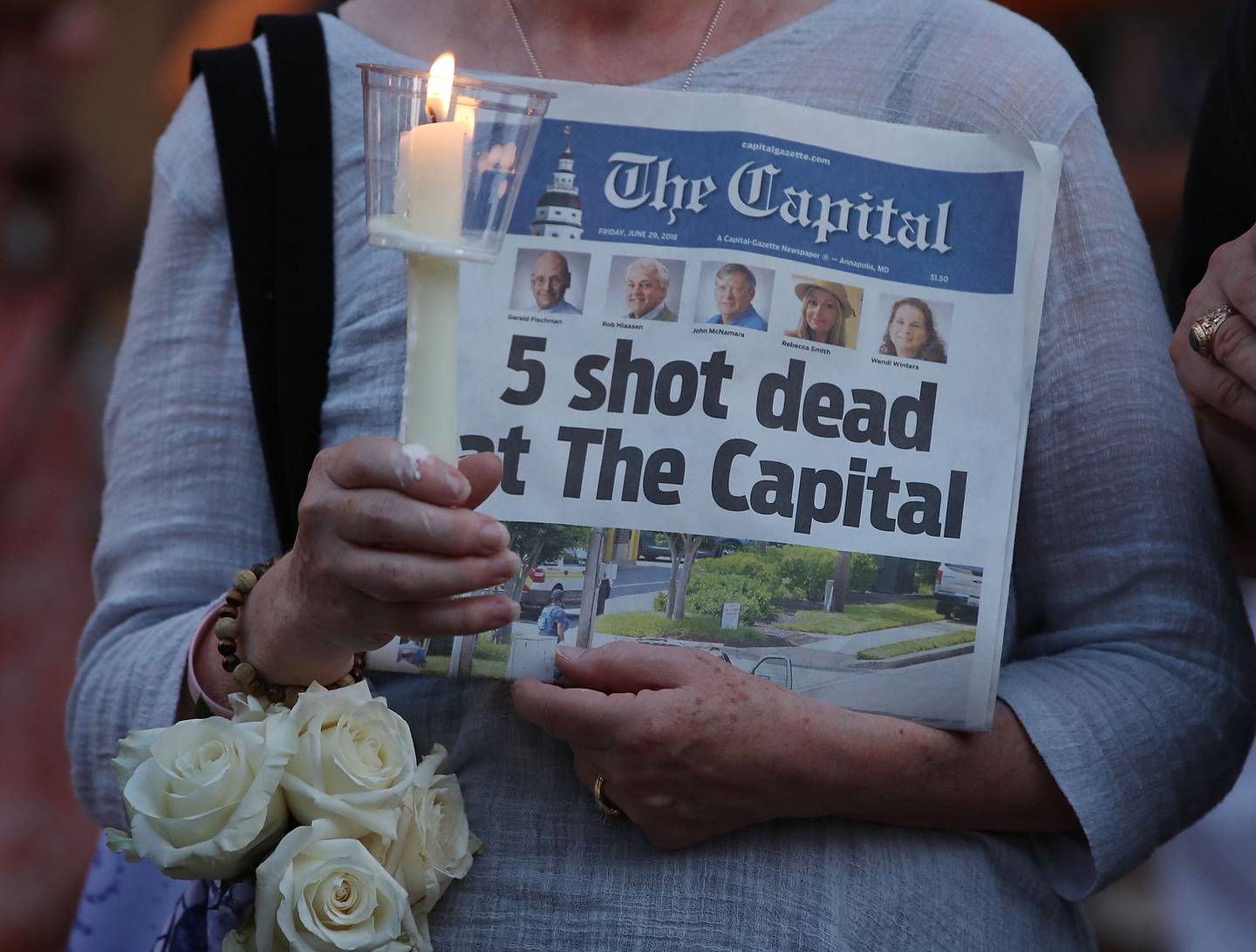 ANNAPOLIS - A women holds an edition of the Capital Gazette newspaper during a candlelight vigil to honor the five people who were shot and killed on June 29, 2018 in Annapolis.
