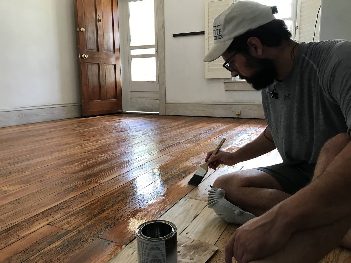 Reporter Tim Prudente applies finish on the wood floors of his Baltimore rowhome.