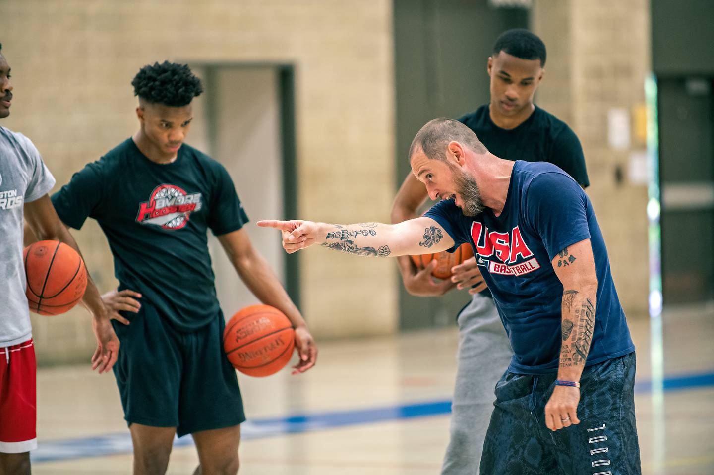 Sam Brand, Director of the Team Melo AAU Program, works with players at a clinic.