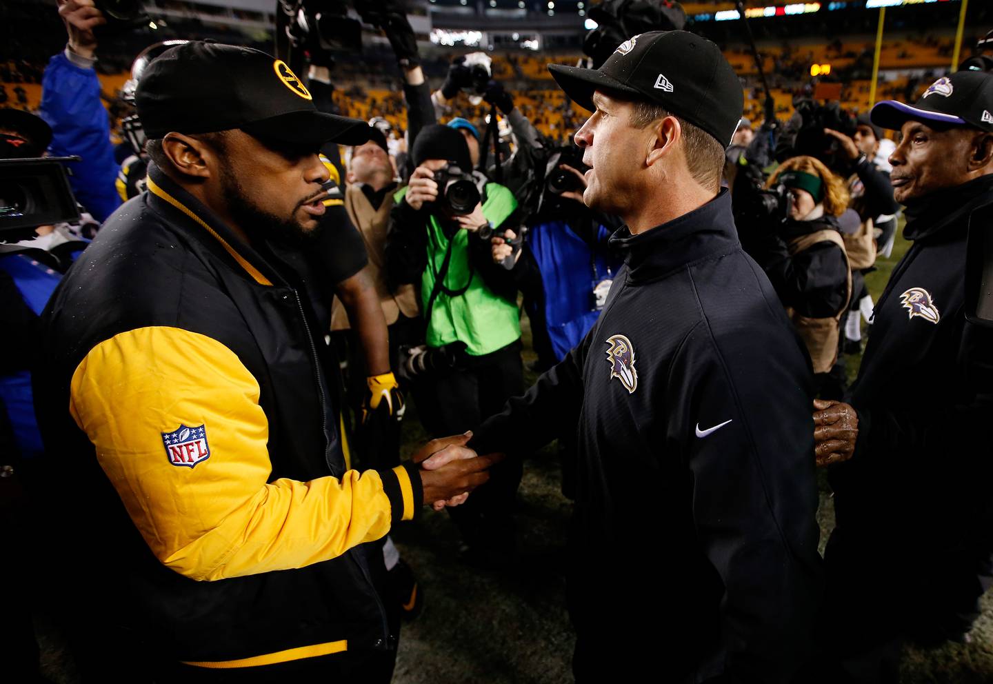 PITTSBURGH, PA - JANUARY 03: Head coach Mike Tomlin of the Pittsburgh Steelers meets head coach John Harbaugh of the Baltimore Ravens after the Ravens defeated the Steelers 30-17 in their AFC Wild Card game at Heinz Field on January 3, 2015 in Pittsburgh, Pennsylvania.