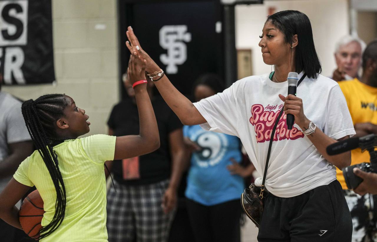 LSU basketball star and Baltimore native Angel Reese hosted a basketball clinic at Saint Frances Academy on July 19, 2023. Reese watches as the young women do layups on the court and offers them words of encouragement and high-fives.
