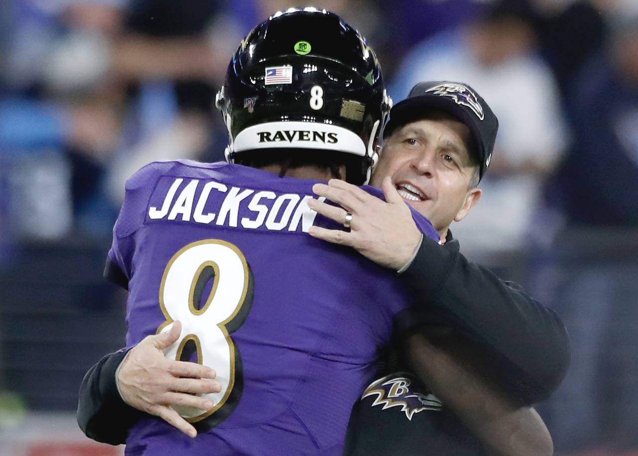 Head coach John Harbaugh of the Baltimore Ravens and quarterback Lamar Jackson #8 embrace prior to the AFC Divisional Playoff game against the Tennessee Titans at M&T Bank Stadium on January 11, 2020 in Baltimore, Maryland.