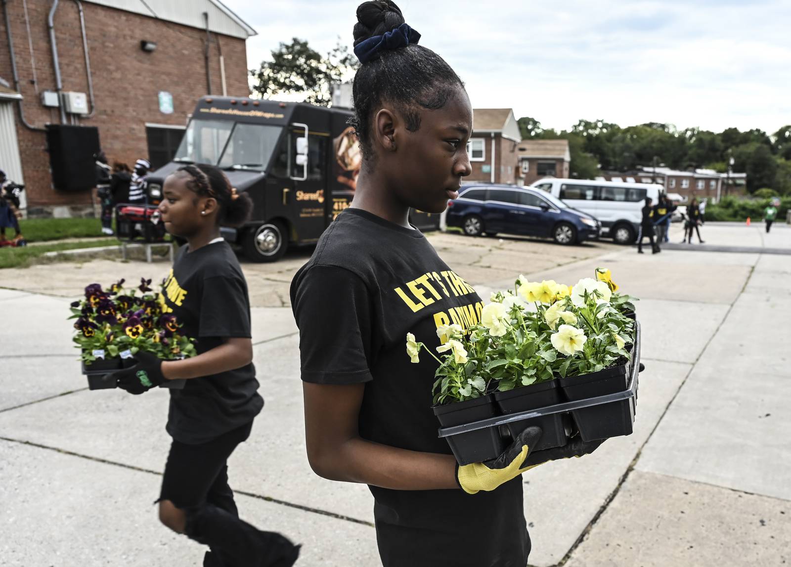 Youth volunteers deliver flowrs for new beds at the Brooklyn Homes' Healing Day event on Saturday
