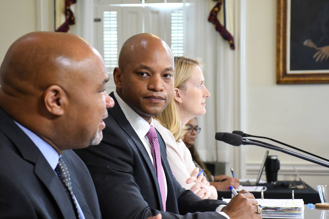 Maryland Gov. Wes Moore, center, watches as state Treasurer Dereck Davis speaks during a meeting of the state Board of Public Works on July 5, 2023. Also sitting on the board is state Comptroller Brooke Lierman.