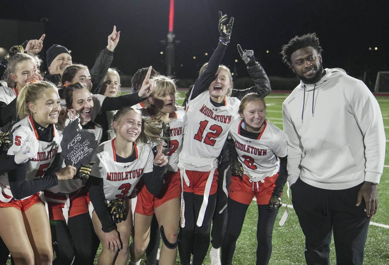 Raven’s Patrick Queen poses with Middletown players during the Girls flag Championship at the Under Armour’s “The Stadium at the House” in Baltimore, Wednesday.