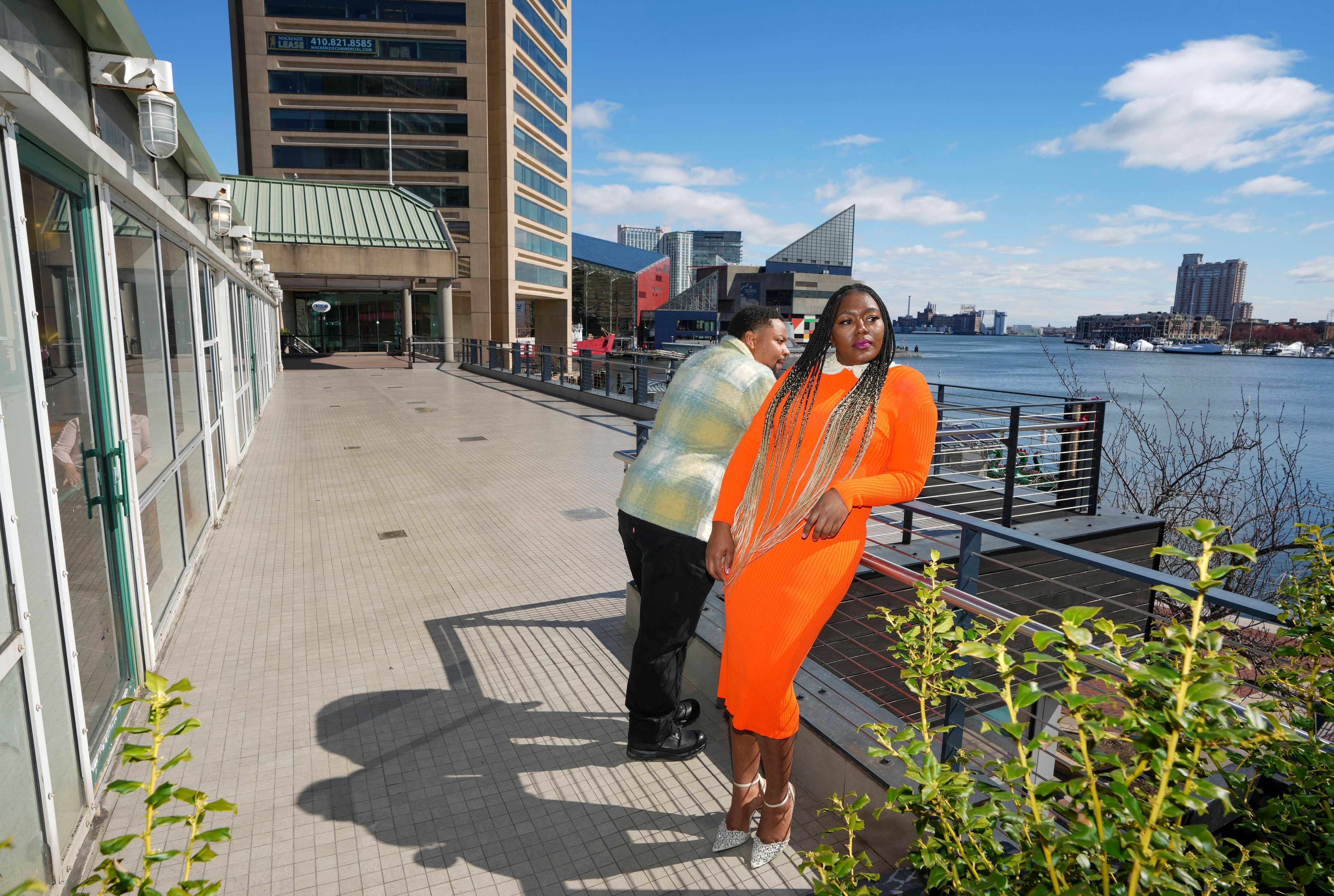 New business owner Amanda Mack takes in the view with her partner Jarrod Mack, stand on the balcony of her new retail space in the Harborplace shopping complex, in Baltimore, MD., on March 11, 2023.
