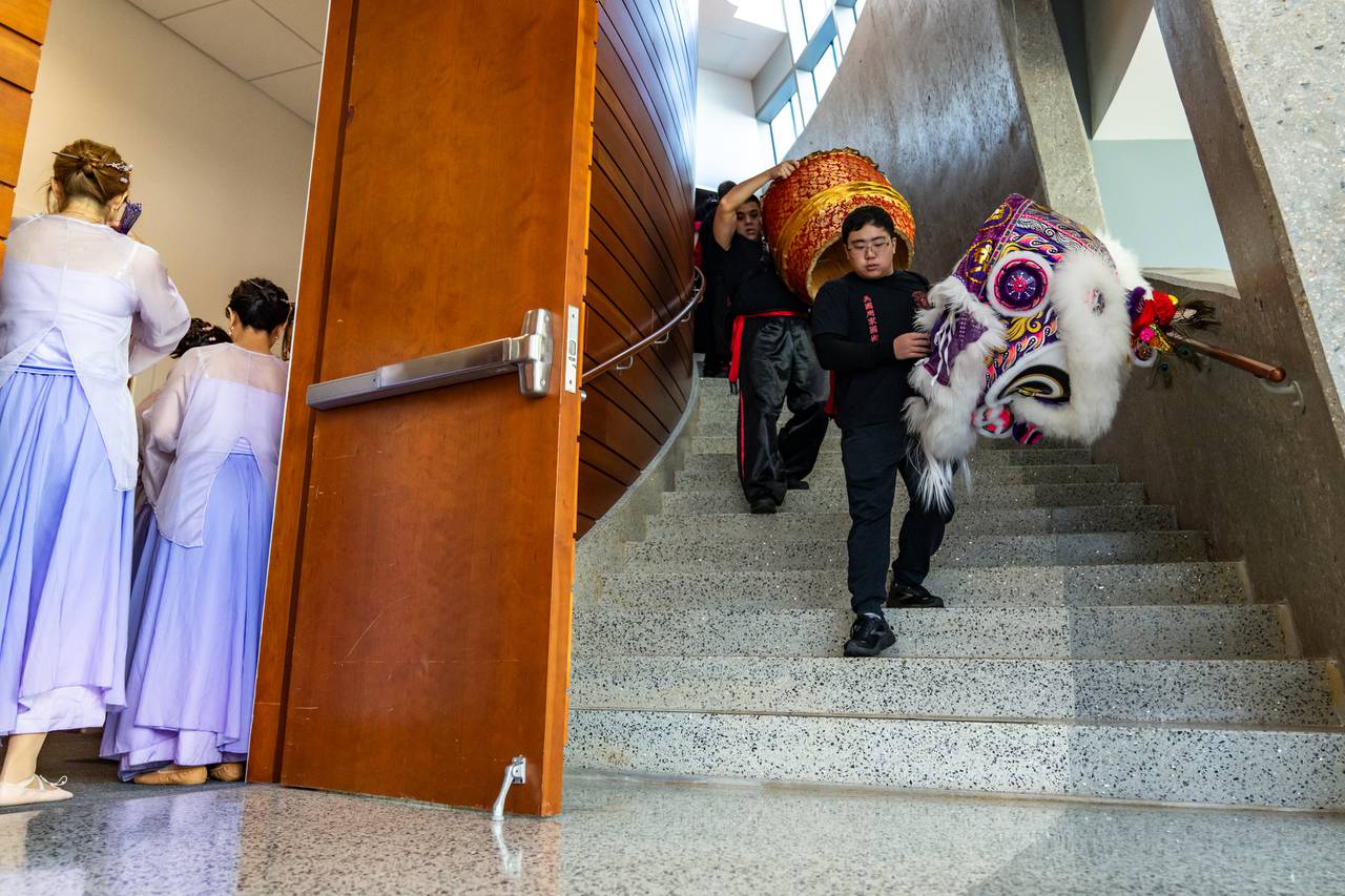 Eric Lam and Donny Yau carry out the lion head and drum, respectively, after performing at the United States Pharmacopeia as another group waits to go onstage in Rockville, Md. on Wednesday, Feb. 21, 2024.