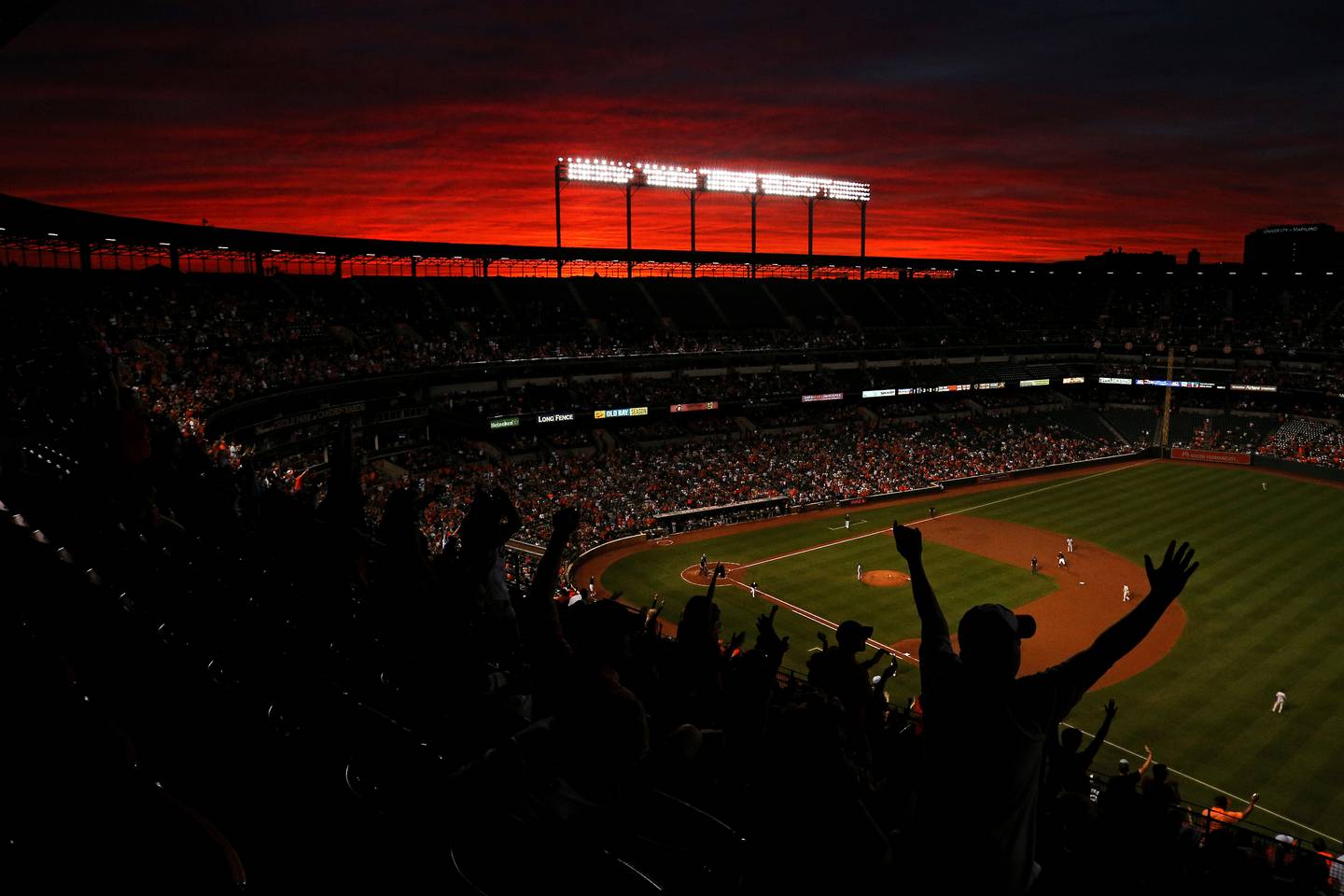 Fans cheer under a sunset as Pedro Alvarez #24 of the Baltimore Orioles rounds the bases after hitting a two run home run against the New York Yankees during the second inning at Oriole Park at Camden Yards on September 2, 2016 .