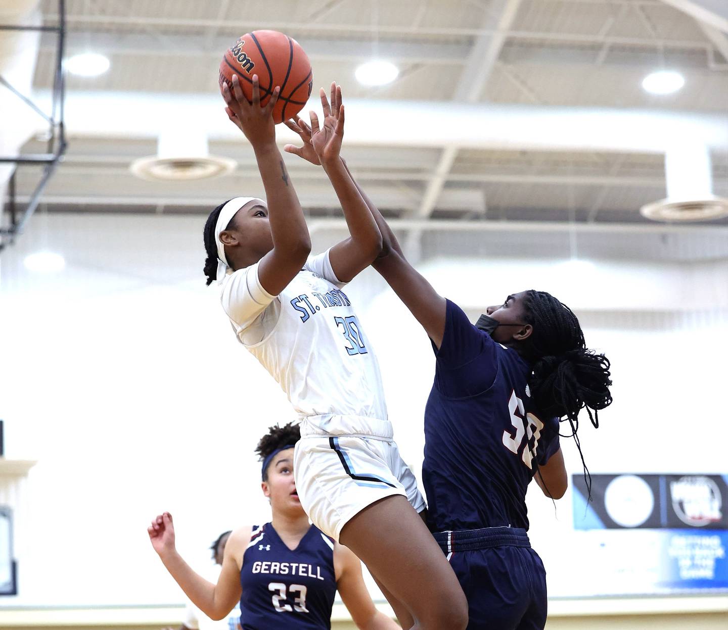 St. Timothy's senior guard Aryss Macktoon elevates over Gerstell Academy junior center Eniyah Stinette as Falcon teammate Kate Roberts approaches.