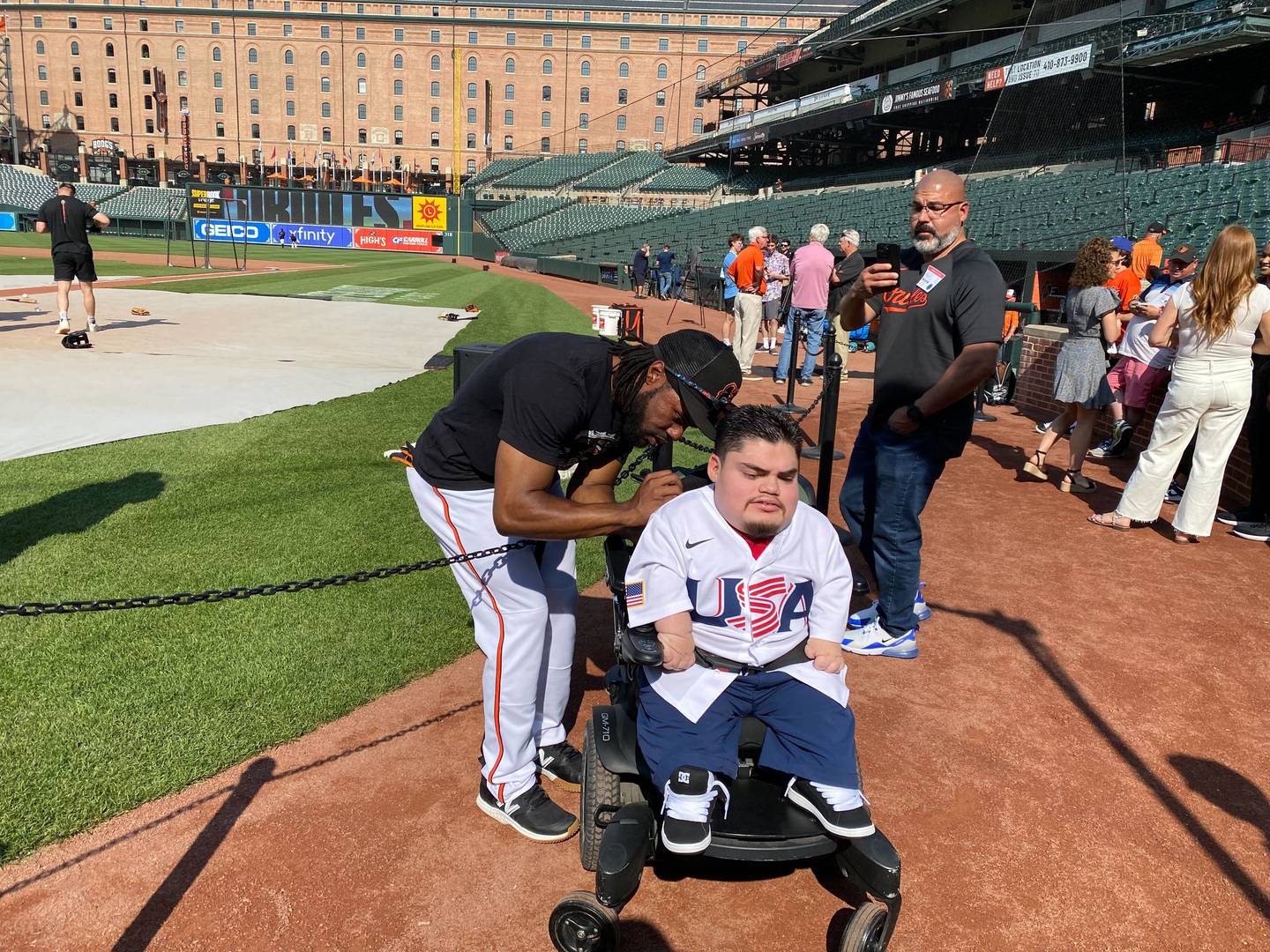 Orioles outfielder Cedric Mullins signs the back of A.J. Rodriguez's jersey.