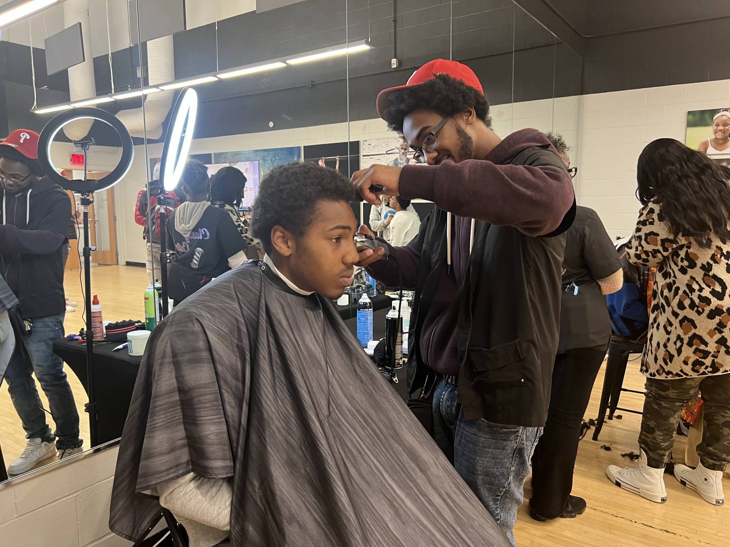 Michael Williams, 17, gets a free haircut from Lawrence Mayo, a barber, Friday afternoon.