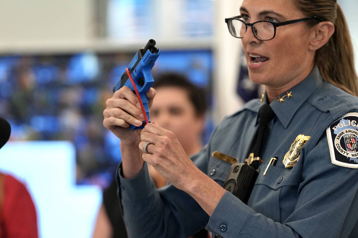 Deputy Chief Roberts demonstrates how to use the gun safety lock a press conference hosted by County Executive Steuart Pittman, Ann Arundel department of Health and the Ann Arundel County Public library on April 13, 2023.