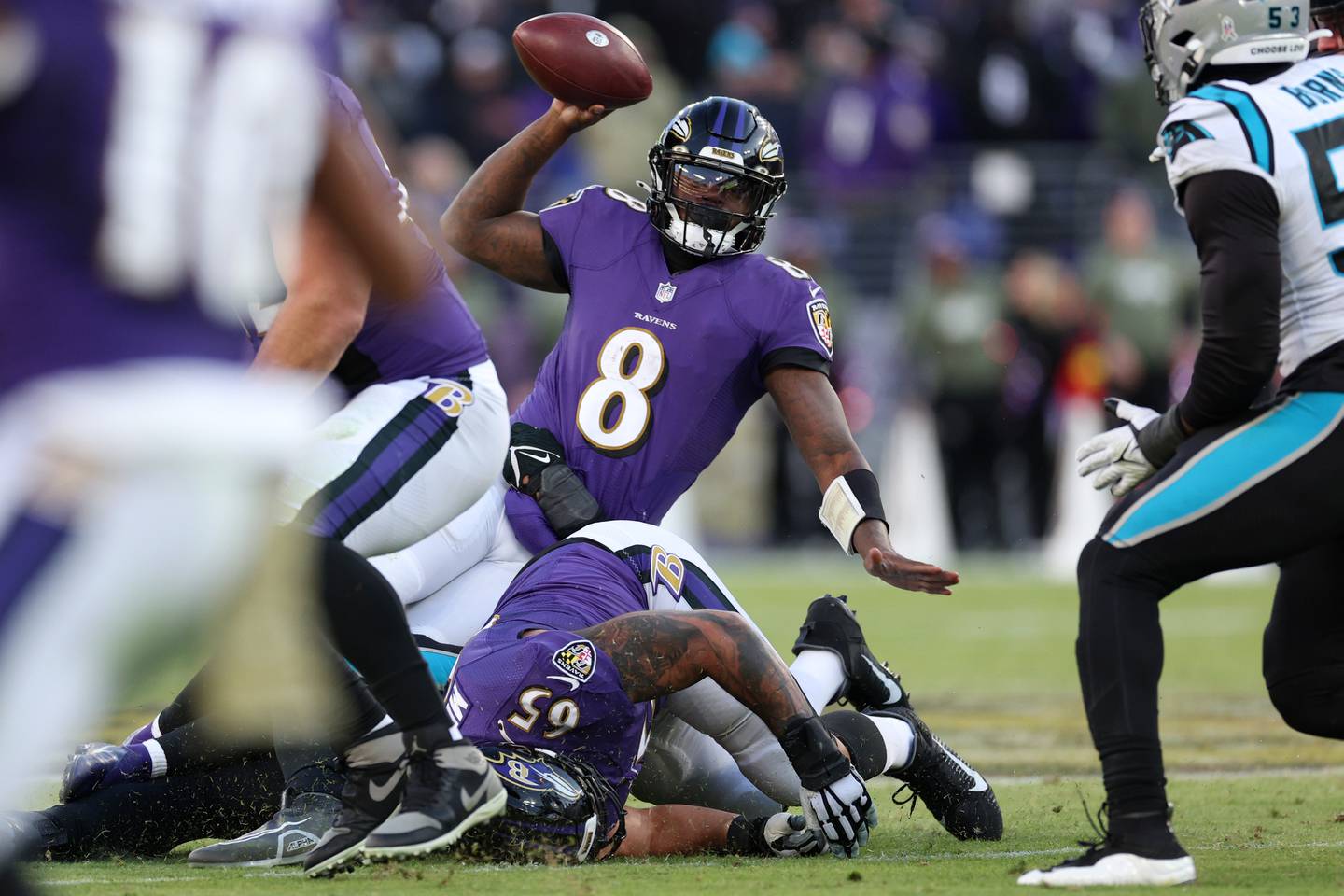 BALTIMORE, MARYLAND - NOVEMBER 20: Lamar Jackson of the Baltimore Ravens works to throw ball away in the fourth quarter of a game against the Carolina Panthers at M&T Bank Stadium on November 20, 2022 in Baltimore, Maryland.