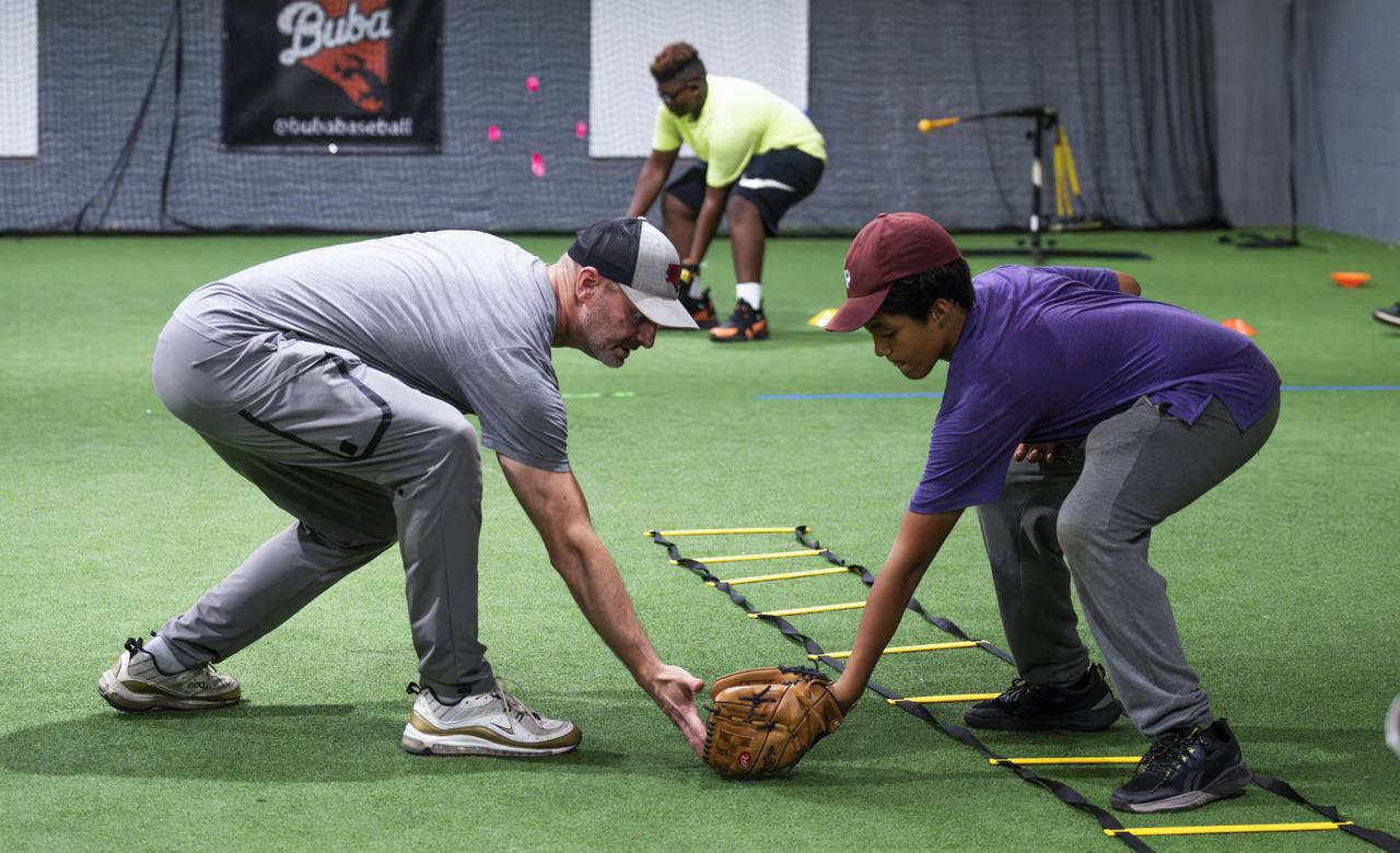 Coach Andy Weltinger, founder, works with children on their catching skills. Children learn baseball skills at the Baltimore Urban Baseball Academy, BUBA, in South Baltimore on October 4, 2023.