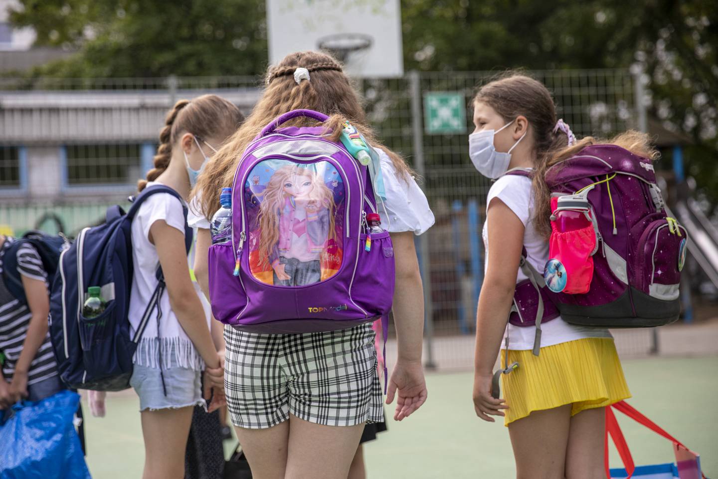 BERLIN, GERMANY - AUGUST 10: Children wearing protective face masks arrive for the first day of classes of the new school year at the GuthsMuths elementary school during the coronavirus pandemic on August 10, 2020 in Berlin, Germany. Classes at schools across Germany are beginning this month with face mask requirements varying by state. Coronavirus infection rates are climbing again in Germany, from an average of 400 new cases per day about two weeks ago to over 1,100 yesterday, according to the Robert Koch Institute.