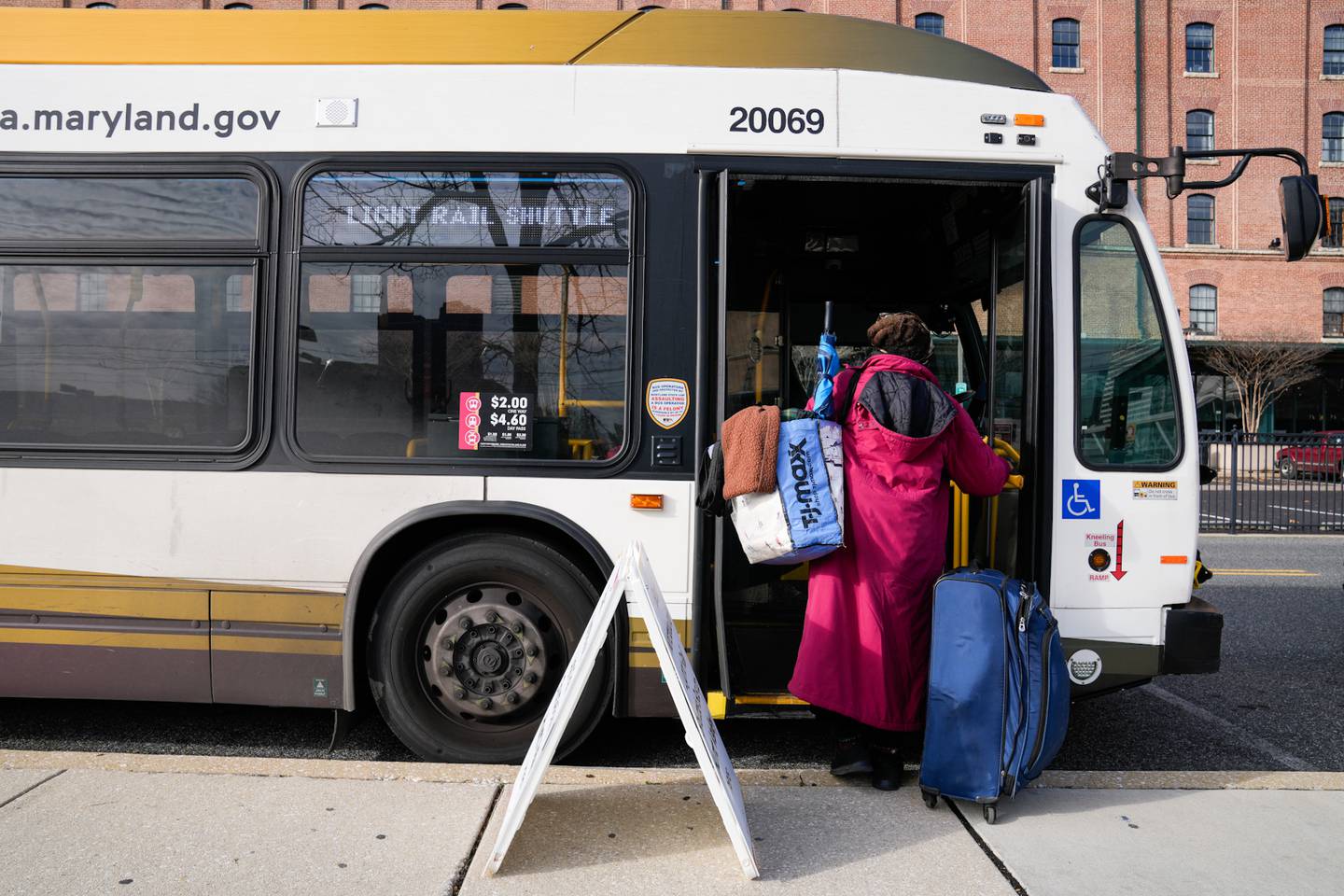 Wanda, a resident of the Baltimore area, boards a northbound light rail shuttle bus on Friday, Dec. 8, 2023. She often uses the light rail services and learned that it was down when she heard the announcement on the platform.