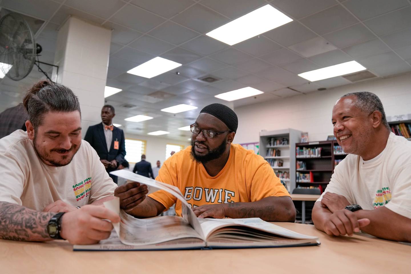 Kyle Longerbeam, Jermain Williams and Timothy Hawkins, all Bowie State University students, flip through a book in the Maryland Correctional Institution library on August 1, 2023.