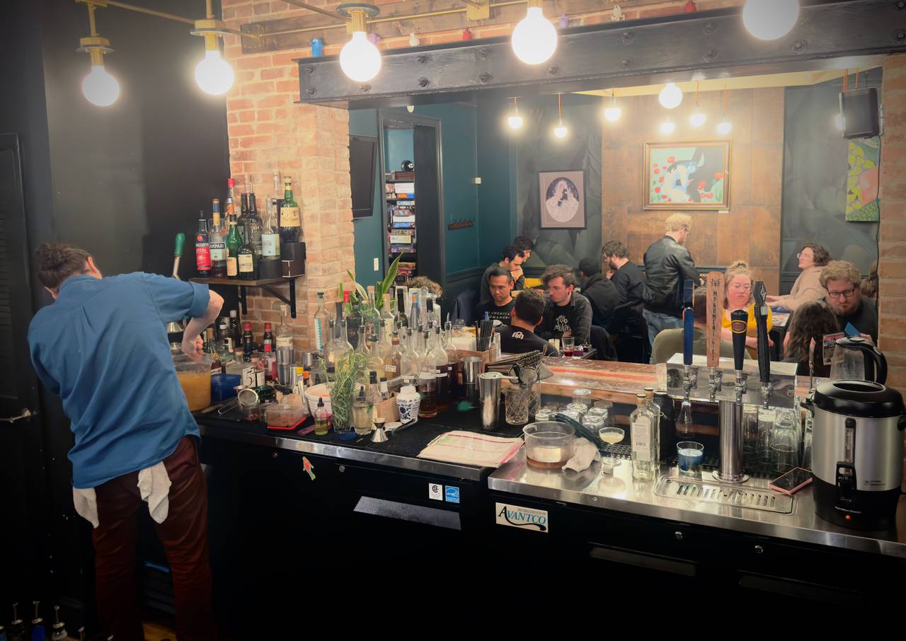 Owner Michael Cohn prepares a fantasy-themed cocktail at Baltimore’s No Land Beyond board game bar as customers play card game Magic: The Gathering.