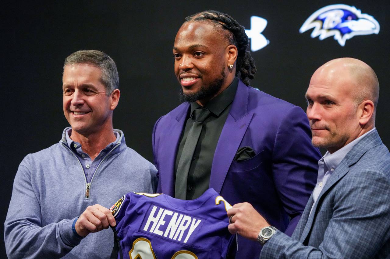 Newly signed running back Derrick Henry, center, stands with Head Coach John Harbaugh, left and General Manager Eric DeCosta as they pose for photos at a press conference at the Under Armour Performance Center on Thursday, March 14.