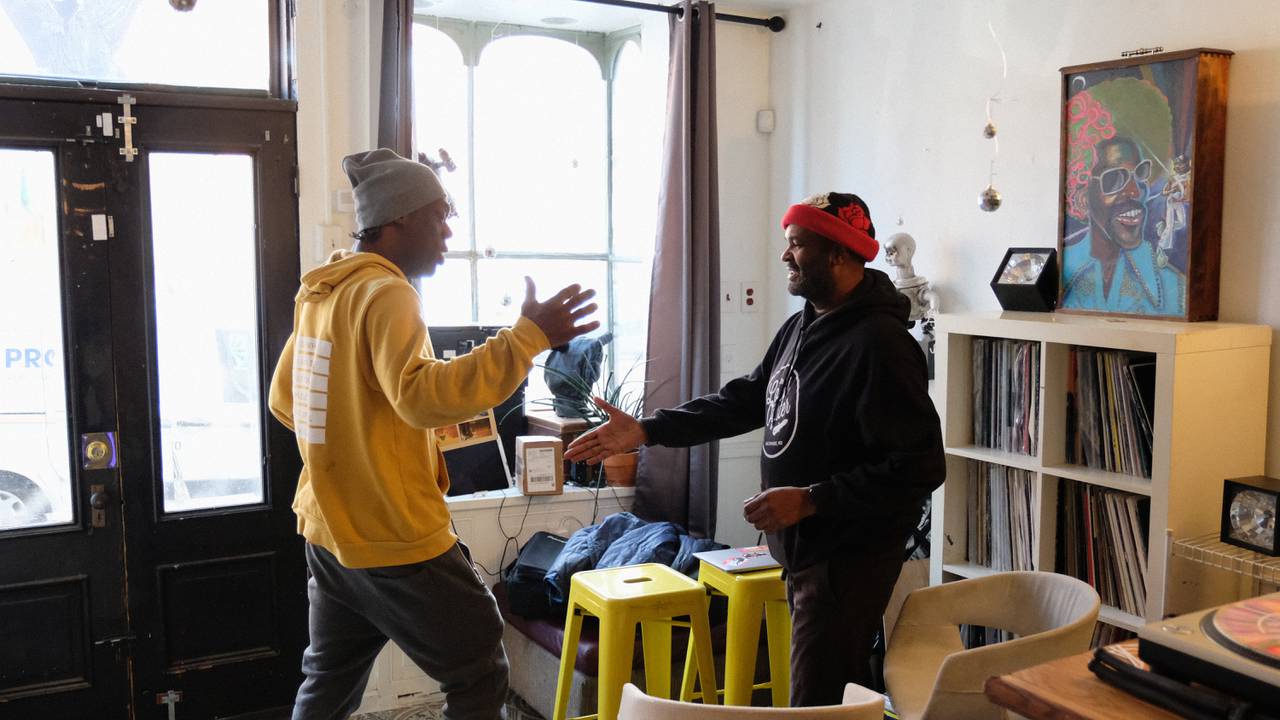 William Hicks and Dura House, long-time friends and members of the music scene in Baltimore, shake hands at Hicks' Mount Vernon store, Mount Vernon Records.