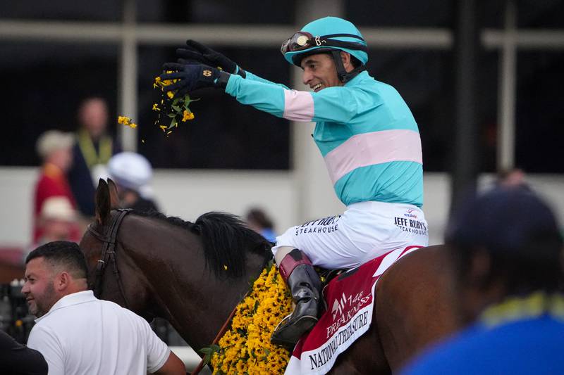 Jockey John Velazquez tosses black-eyed Susan petals after winning the 2023 Preakness Stakes riding National Treasure.