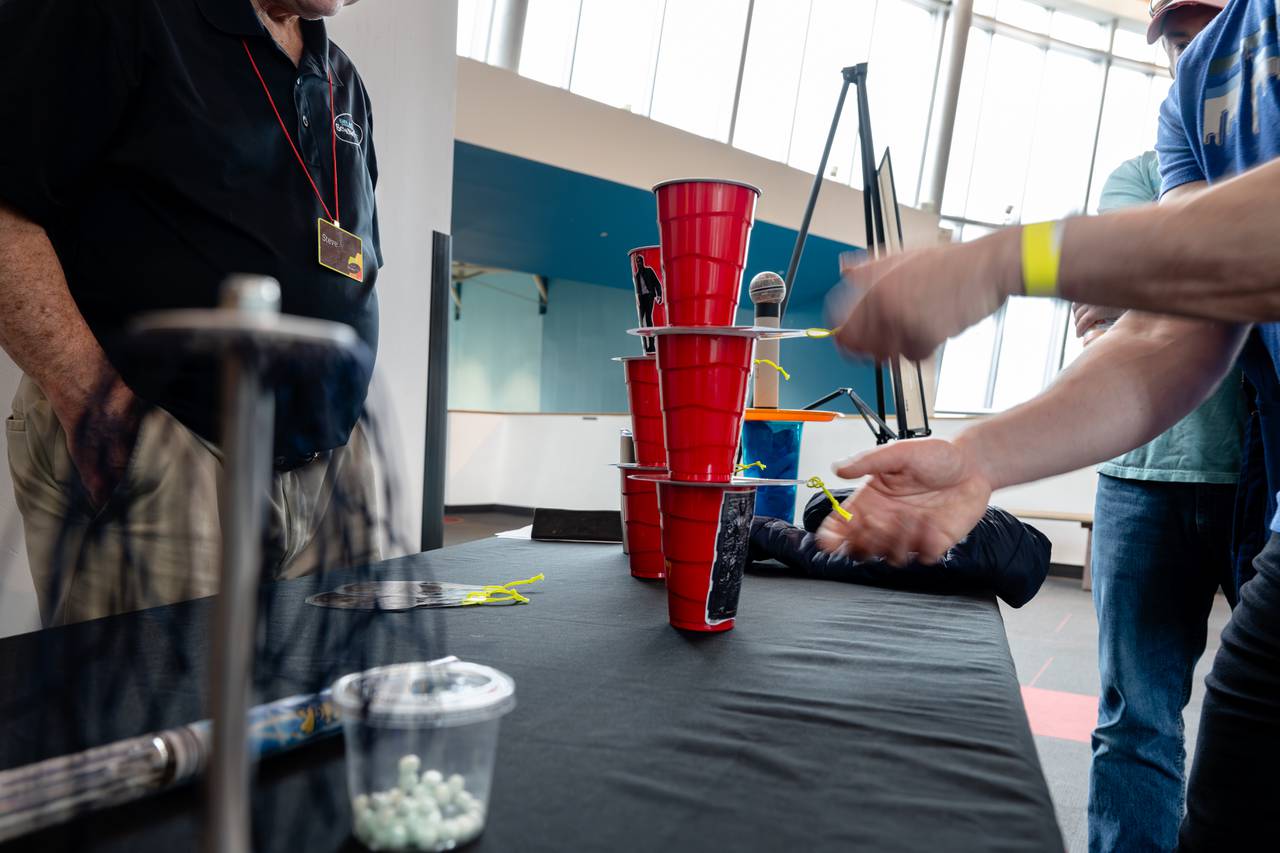 A visitor attempts to pull the Millennium Falcon cards out from between the "Han Solo Cups" as a part of the Use The Force exhibit during the Jedi Academy event at the Maryland Science Center on May 4, 2024, in Baltimore.
