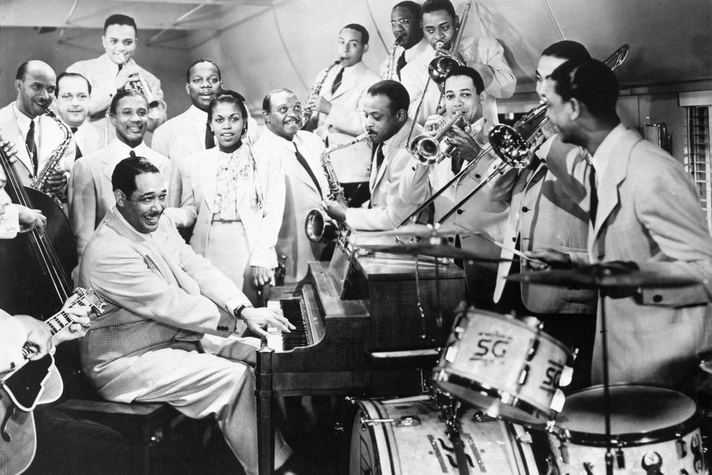 LOS ANGELES - 1943: Composer Duke Ellington, singer Ivie Anderson and drummer Sonny Greer pose for a portrait with their orchestra in 1943 in Los Angeles, California.
