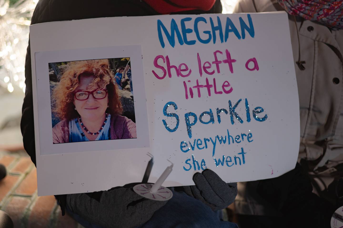 Signs honoring Meghan Lewis' 'sparkle' are held during a memorial in Bel Air, MD on Jan 2, 2024.