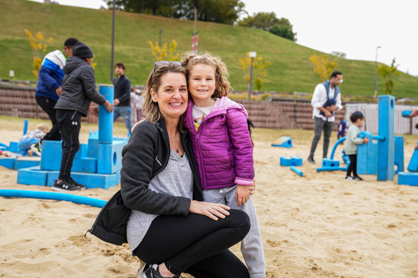 Mom and Daughter pose for a quick photo, while playing in the sand at the Harbor Harvest Festival.