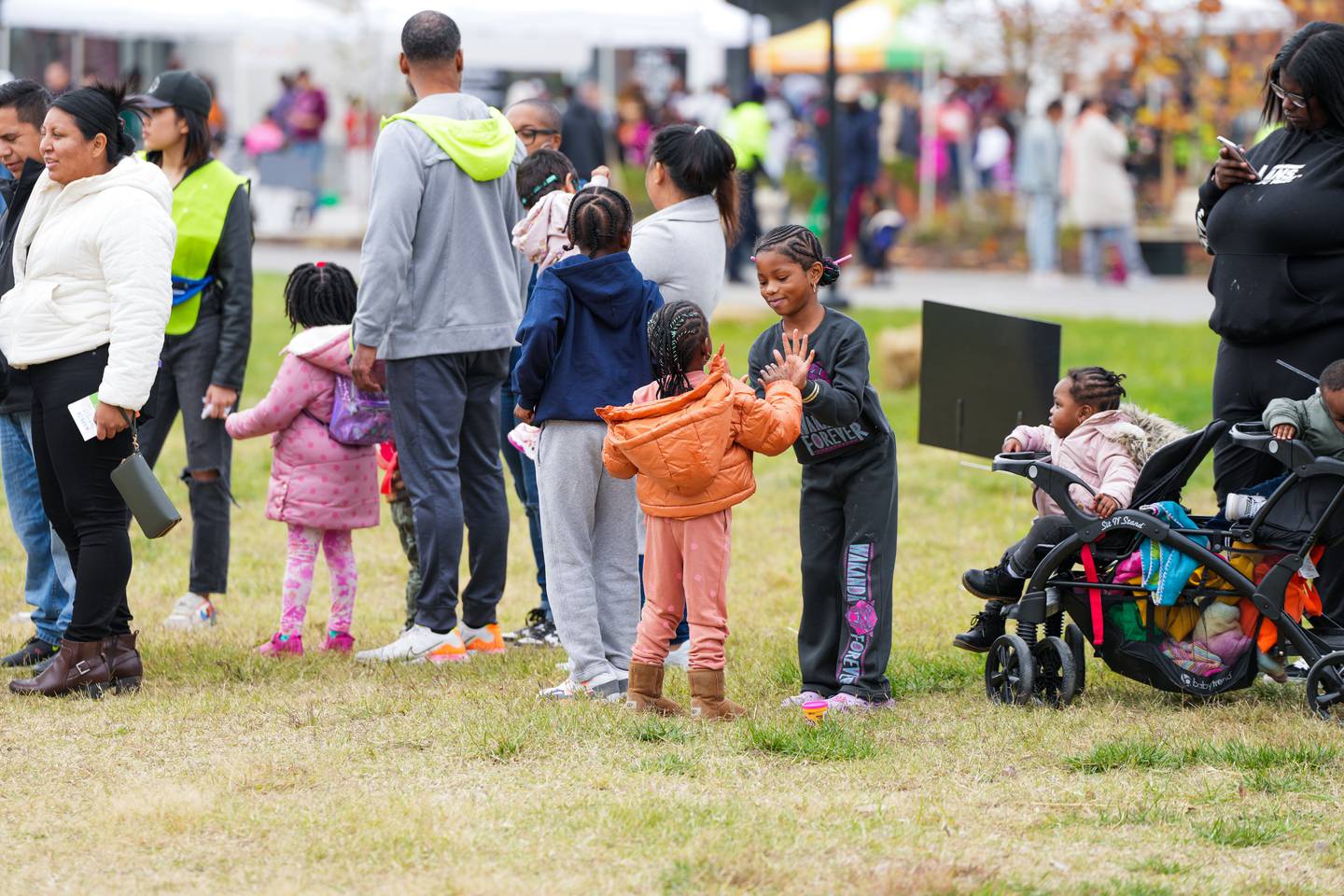 Children play Pat-A-Cake, while waiting in line for one of the many rides and attractions at the Harbor Harvest Festival. The event was located in the Inner Harbor, right next to the newly constructed Rash Field Park.