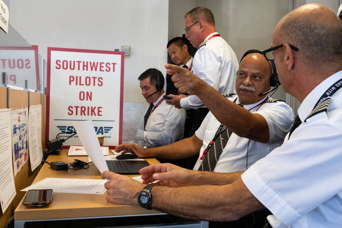 Southwest Airlines pilots learn how to do pilot tracking, one pilot who's wearing a headset pointing.