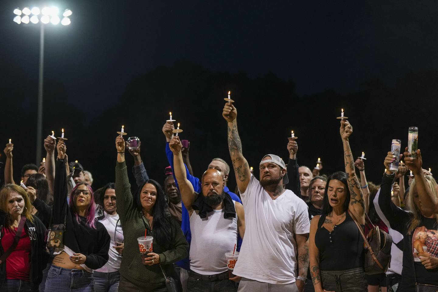 Loved ones hold up candles and sing the song "The Crossroads" by Bone Thugs and Harmony during the vigil for Wright.