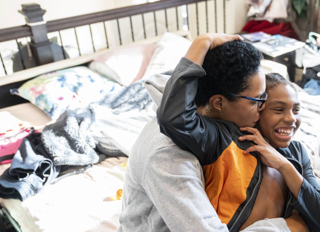 Sharnae Hunt plays with her son, Jacoby Thomas, on the bed they are sharing in Hunt’s mother’s living-room in Glen Burnie, Sunday, December 18, 2022.