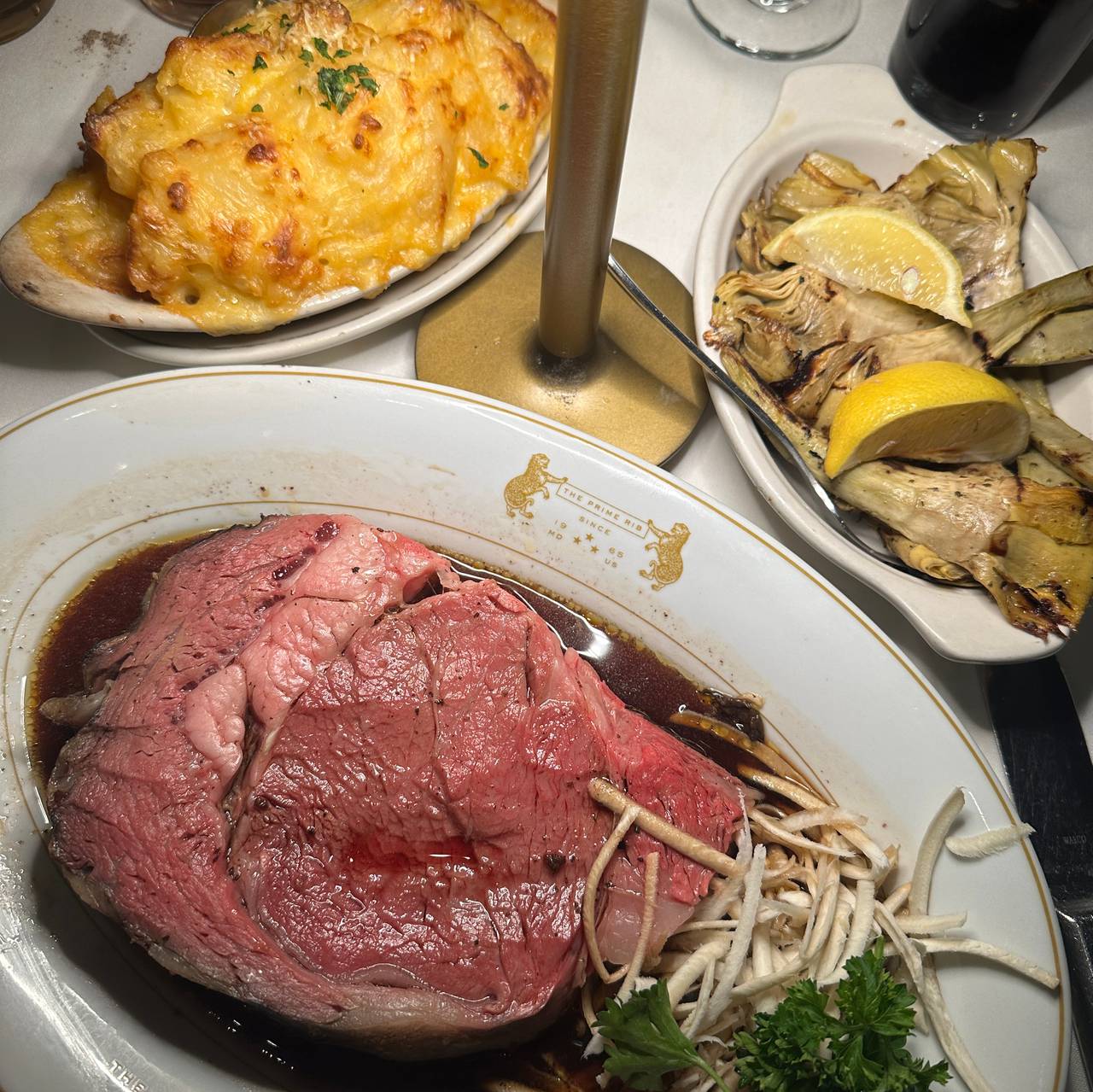 Clockwise from top left: potatoes au gratin, grilled artichoke hearts and prime rib at The Prime Rib.