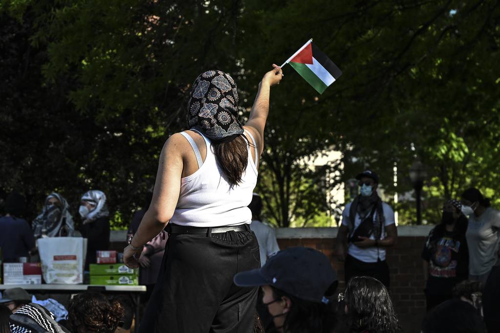 A protester waves a Palestinian flag amid a protest on Monday at Johns Hopkins University.
