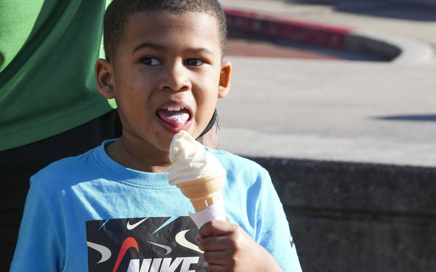 Jordan Freeman, 4, licks an ice cream cone while out on a walk with his family to enjoy the nice weather.