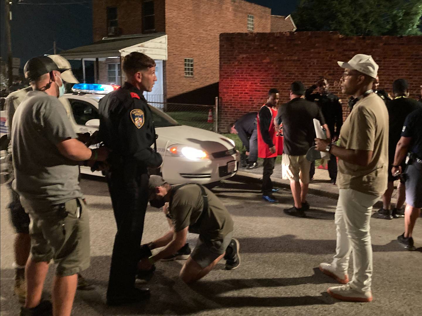 "We Own This City” director Reinaldo Marcus Green, right, and actor Jon Bernthal discuss a scene on location in Northwest Baltimore on Sept. 15, 2021.