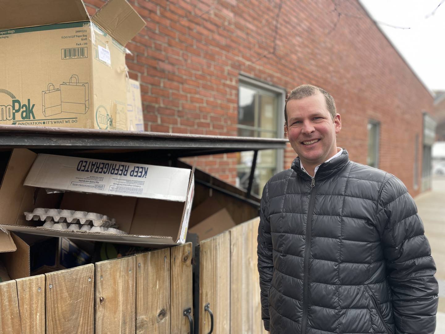 Mark Hollak, founder of Mundea, stands next to the recycling bin at Pitango in Fells Point. Hollak is on a mission to divert trash from landfills in Baltimore and beyond.