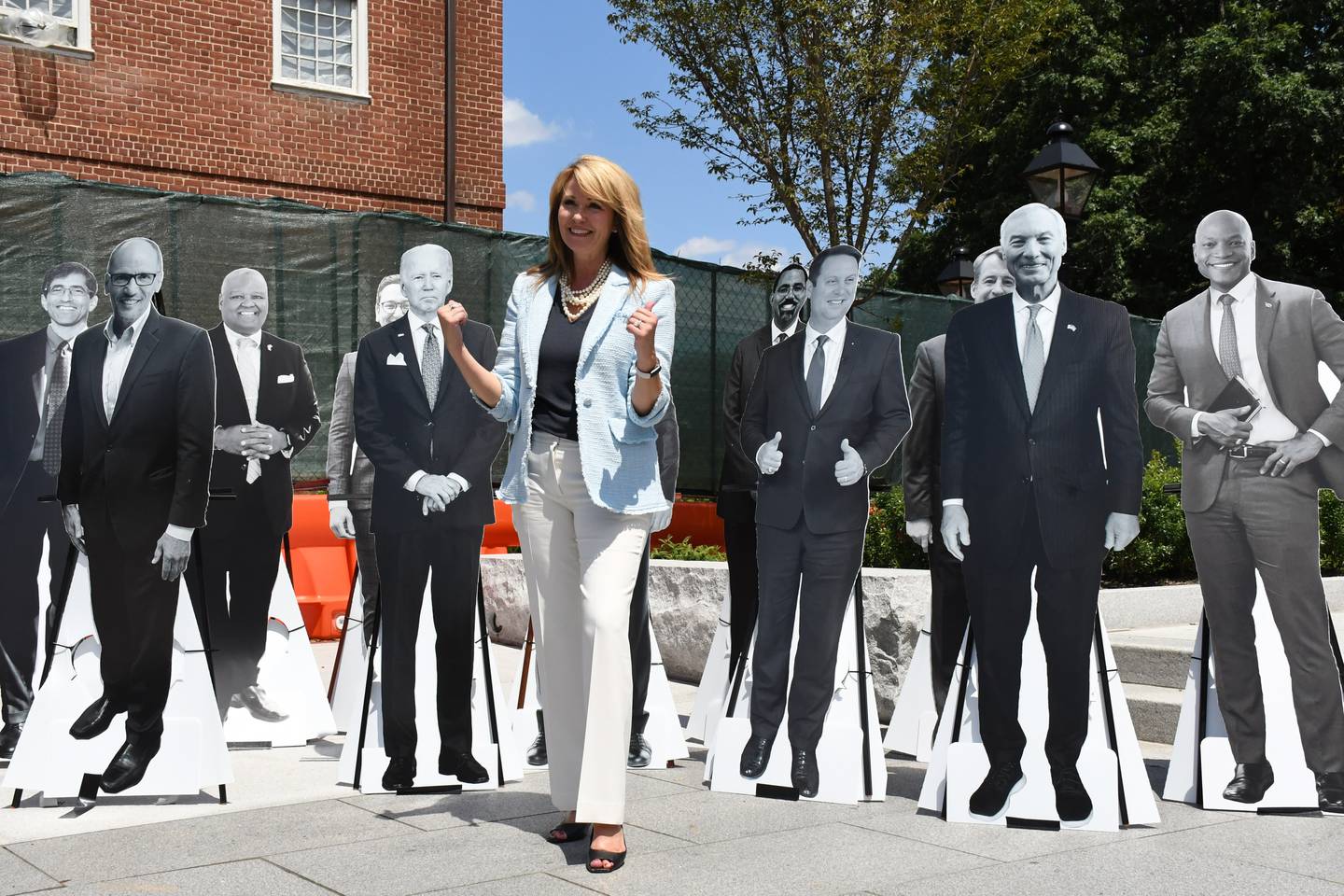 Maryland Republican candidate for governor Kelly Schulz poses for pictures in front of cardboard cutouts of most of the Democratic candidates -- plus Republican candidate Dan Cox and President Joe Biden for good measure -- on Lawyers Mall in Annapolis. Schulz held a news conference to propose tax breaks for Marylanders.