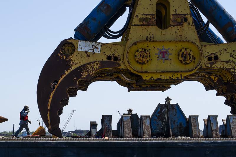 A port worker is pictured next to the 1000-metric-ton wreck grab that is attached to the Chesapeake 1000, a large crane.