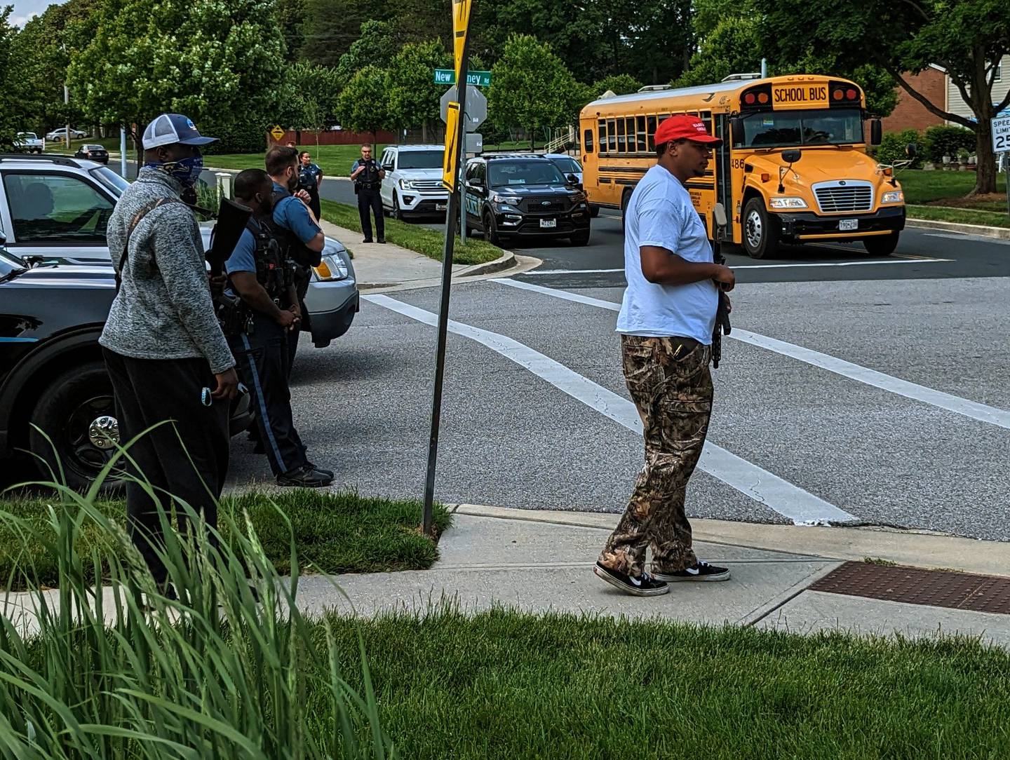 J’den McAdory and a masked gunman stand across the street from a school bus making stops in his neighborhood.
