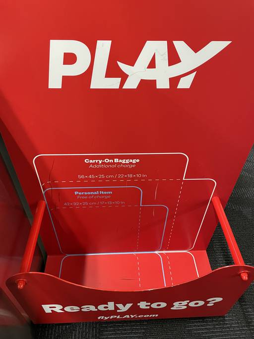 Low-cost carrier Play, whose red measurement box is seen, allows passengers to bring one personal item for free. Carryon costs extra.