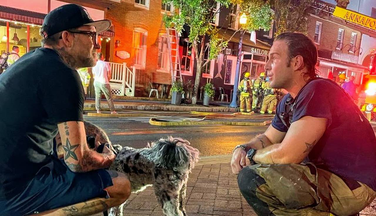 Sailor Oyster Bar co-owner Scott Herbst talks with an Annapolis firefighter on the night of June 8, 2022 that destroyed his restaurant.
