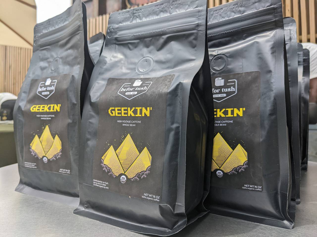 This is a close up picture of Geekin': Befor Tush's first coffee flavor. The packaging is black and gold, with the picture of three pyramids on the front.