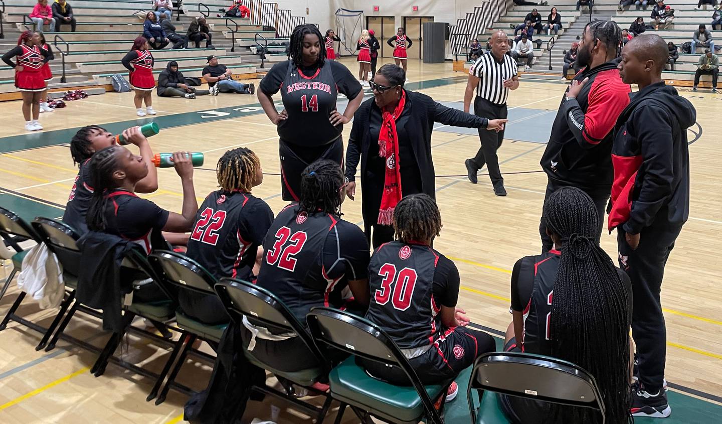 Western basketball coach Tasha Townsend (standing in middle) talks to her team during Friday's Class 4A state girls quarterfinal contest against Charles H. Flowers. The defending state champs and No. 13 Doves advanced to the state semifinals with a 53-42 wire-to-wire victory over the Jaguars in Prince George's County.